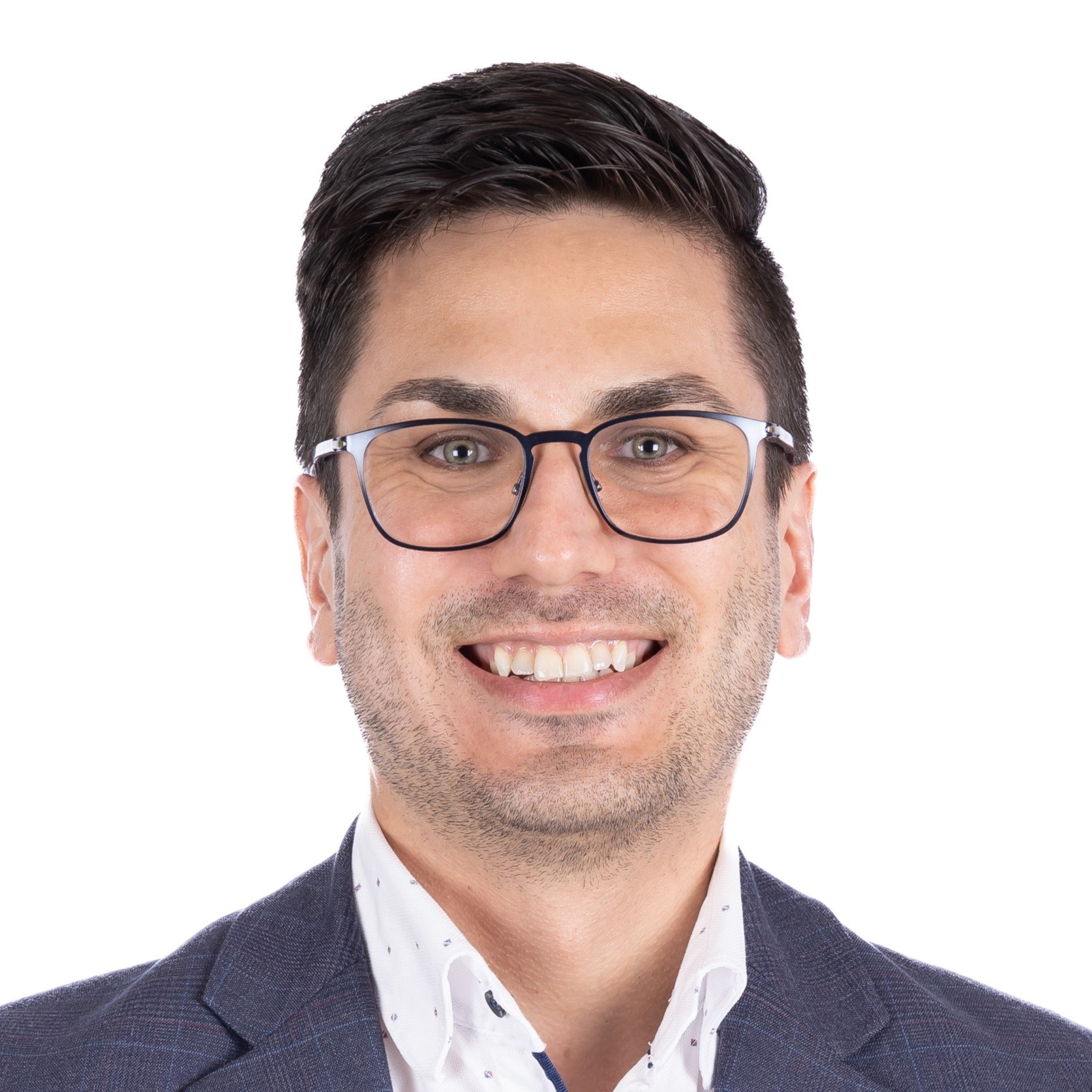 Portrait d'un homme souriant, lunette noir, yeux bleus et cheveux courts foncé.